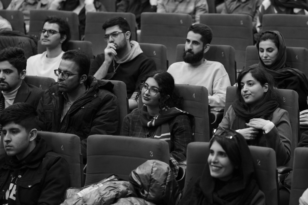 Black and white photo of attentive university students seated in a lecture hall.